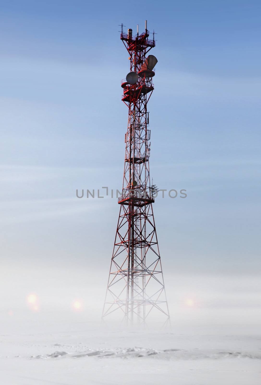 Red communication tower in snowstorm at winter