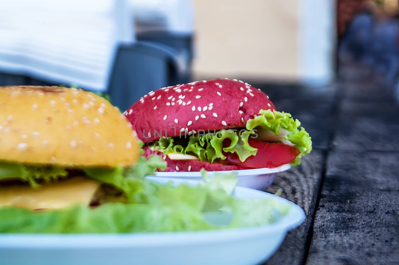 lying a tasty red and yellow burger with salad and sesame  