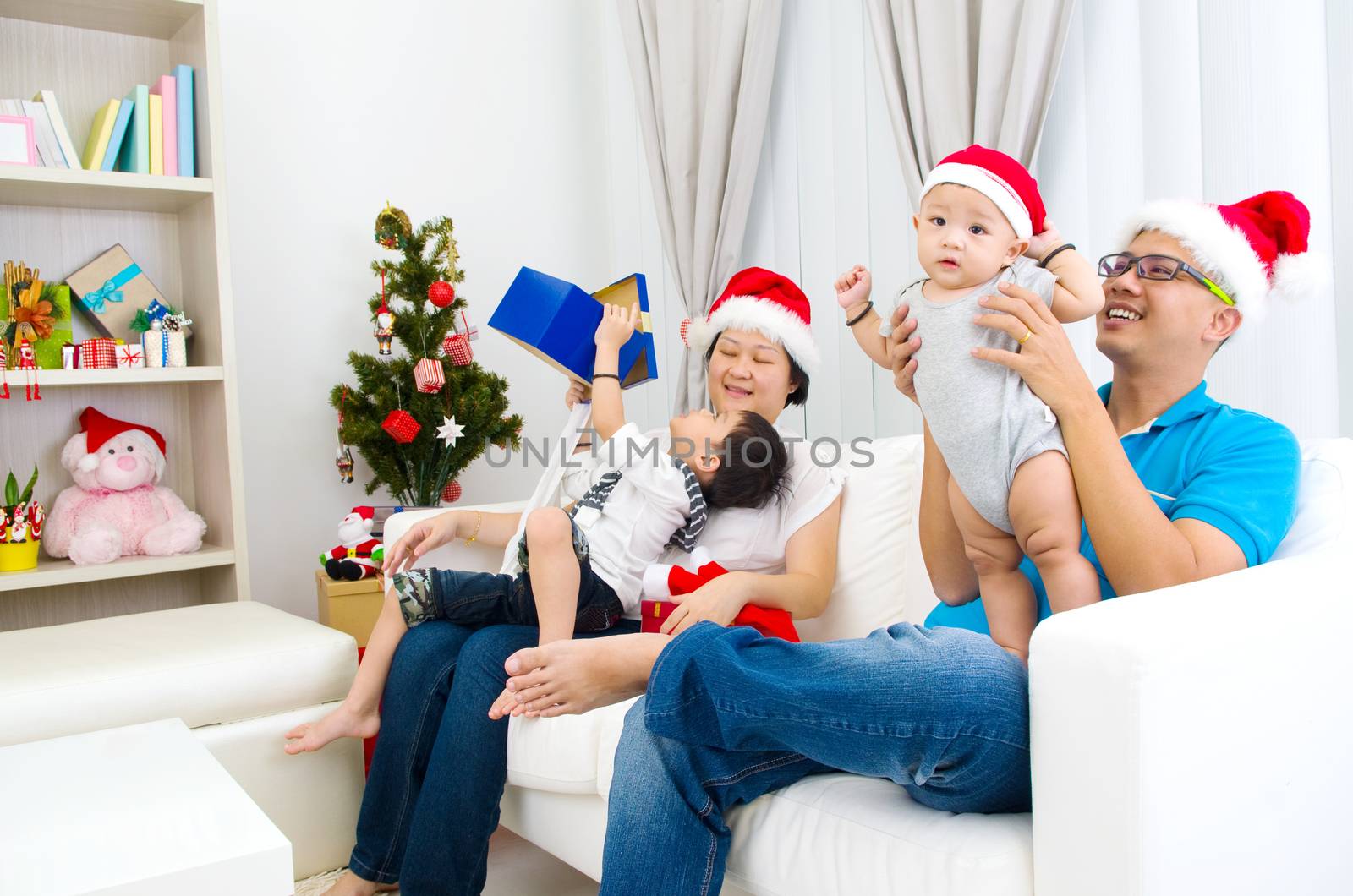 Portrait of happy family members in Santa caps on Christmas eve