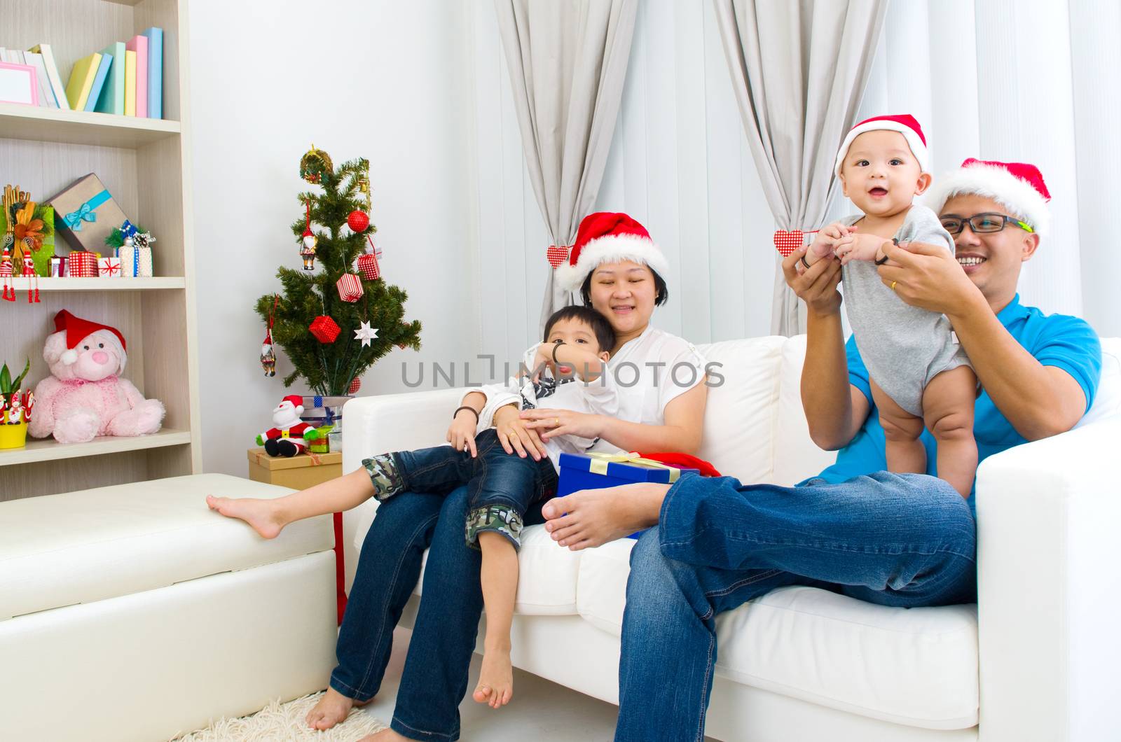 Portrait of happy family members in Santa caps on Christmas eve