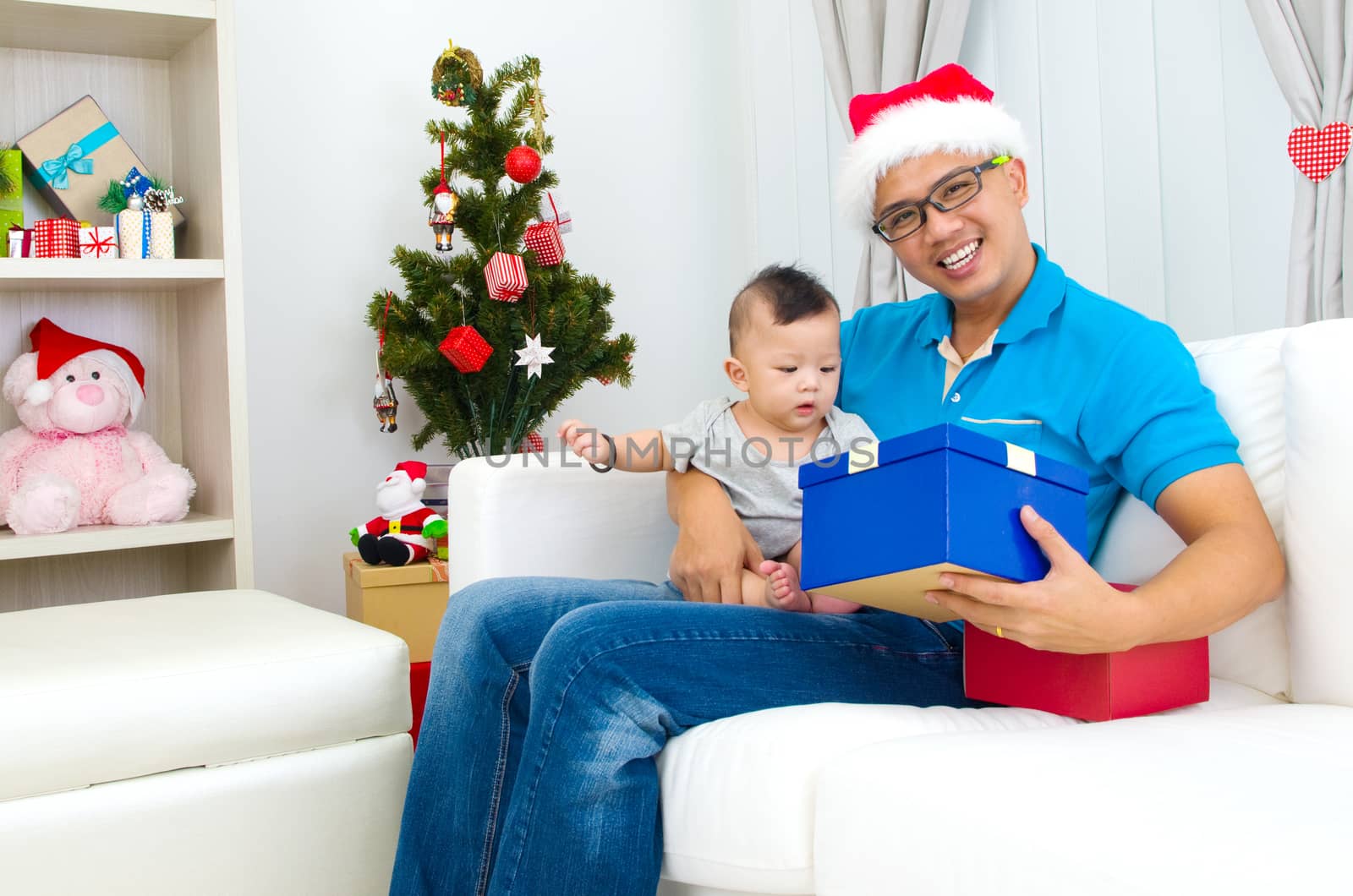 Portrait of happy father and his son in Santa caps on Christmas eve