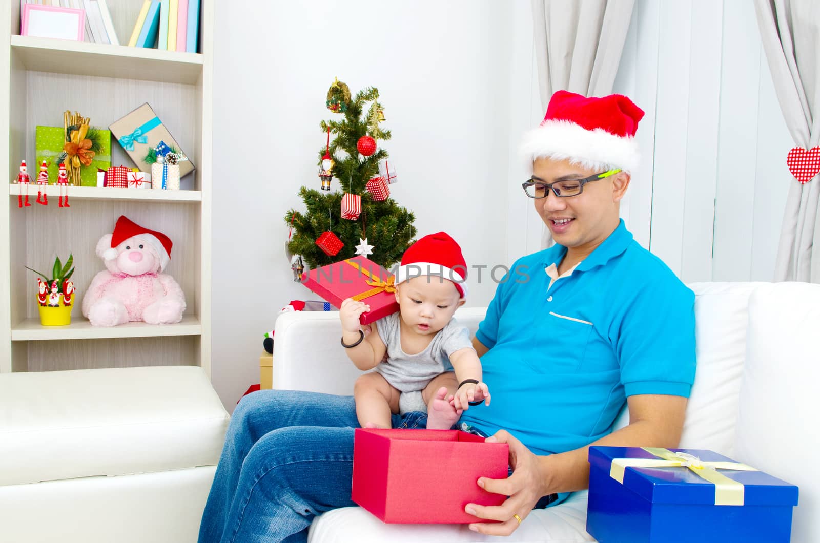 Portrait of happy father and his son in Santa caps on Christmas eve