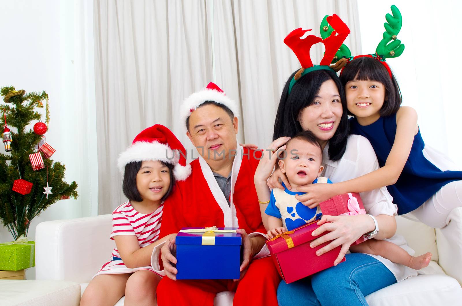 Portrait of happy family members in Santa caps on Christmas eve