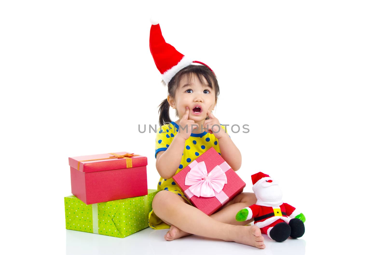 Little Asian girl in Santa hat and Christmas gift box isolated on white
