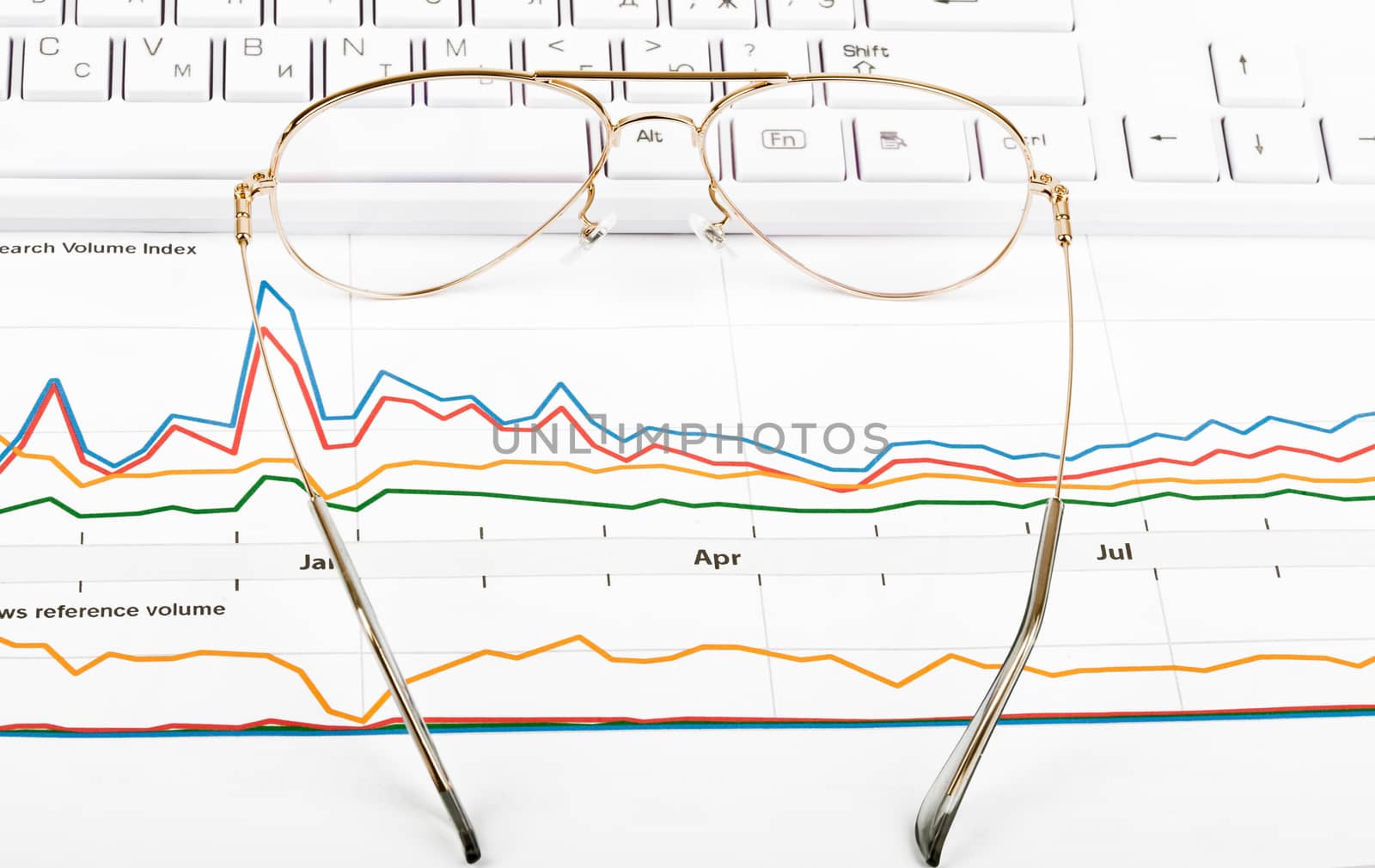 Keyboard with eyeglasses and graphical charts, closeup