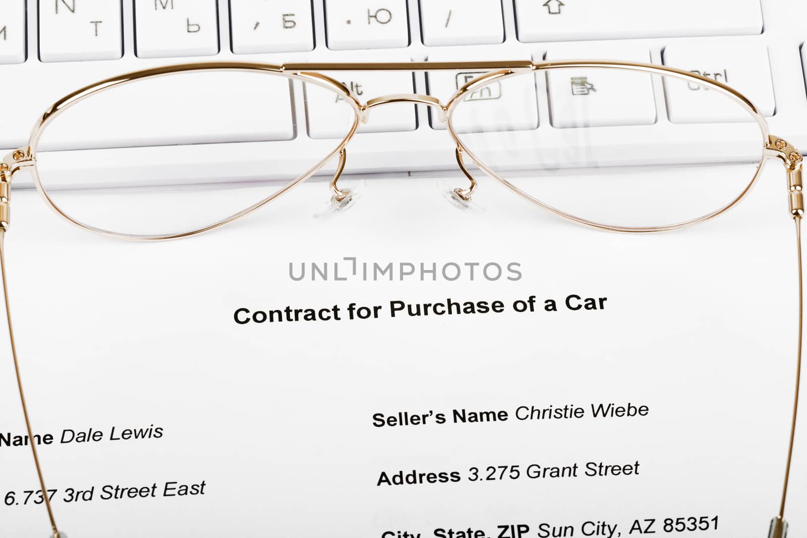 Keyboard with eyeglasses and document of purchase of car