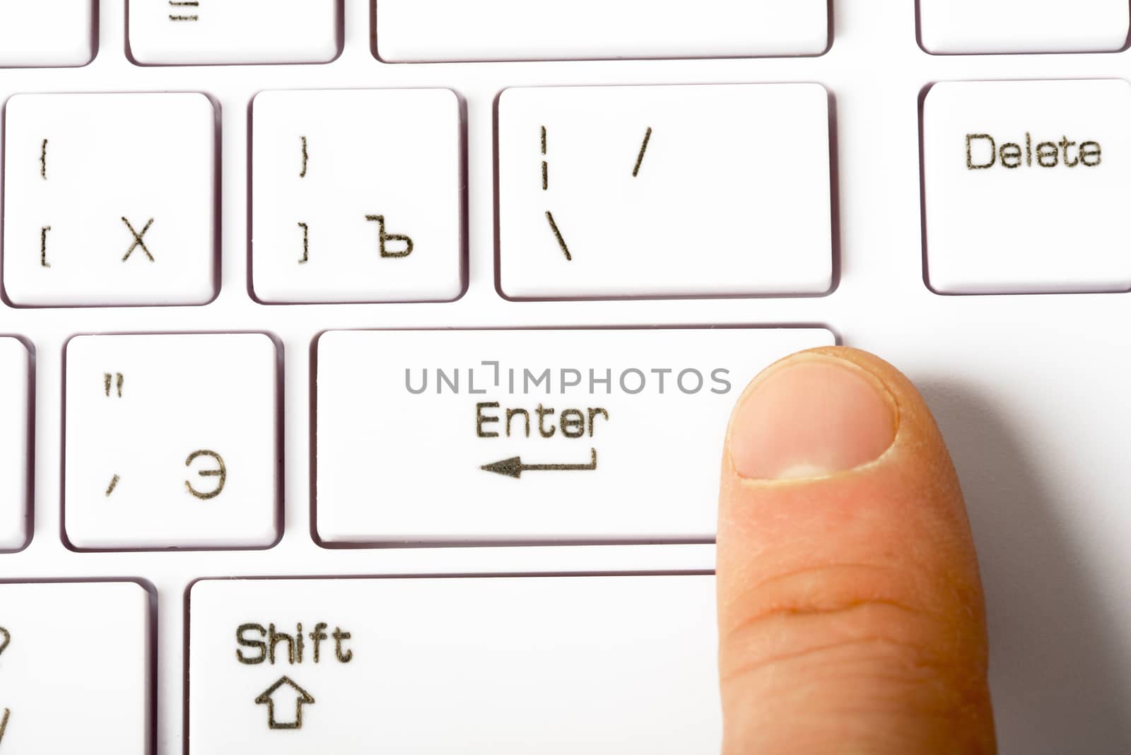 Closeup view of white keyboard with human finger