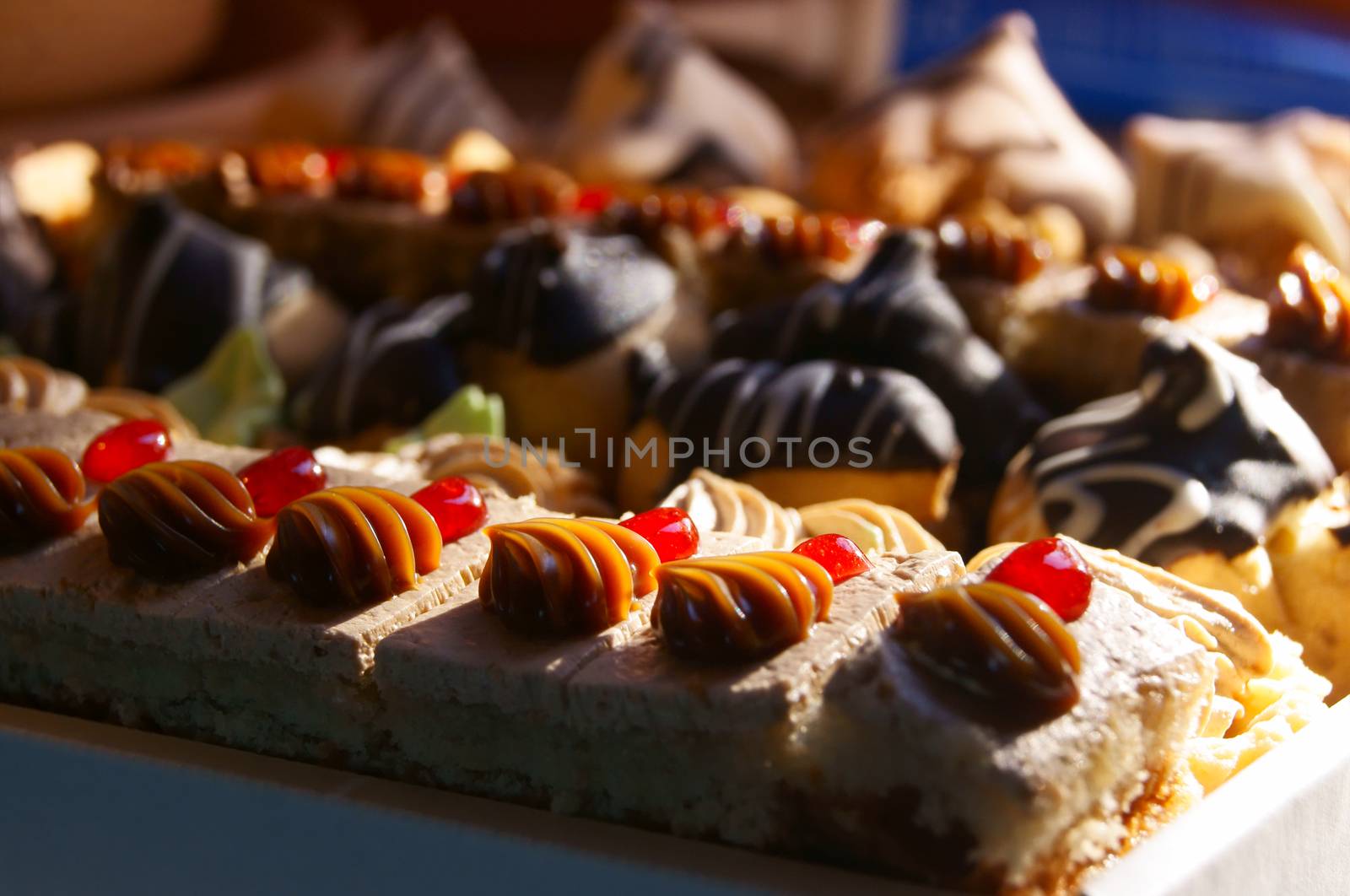 Many little pieces of cake and various tarts in a box