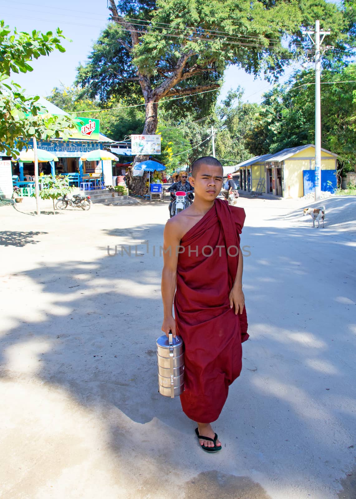 MANDALAY, MYANMAR - November 17, 2015: Young monk with his alms  by devy