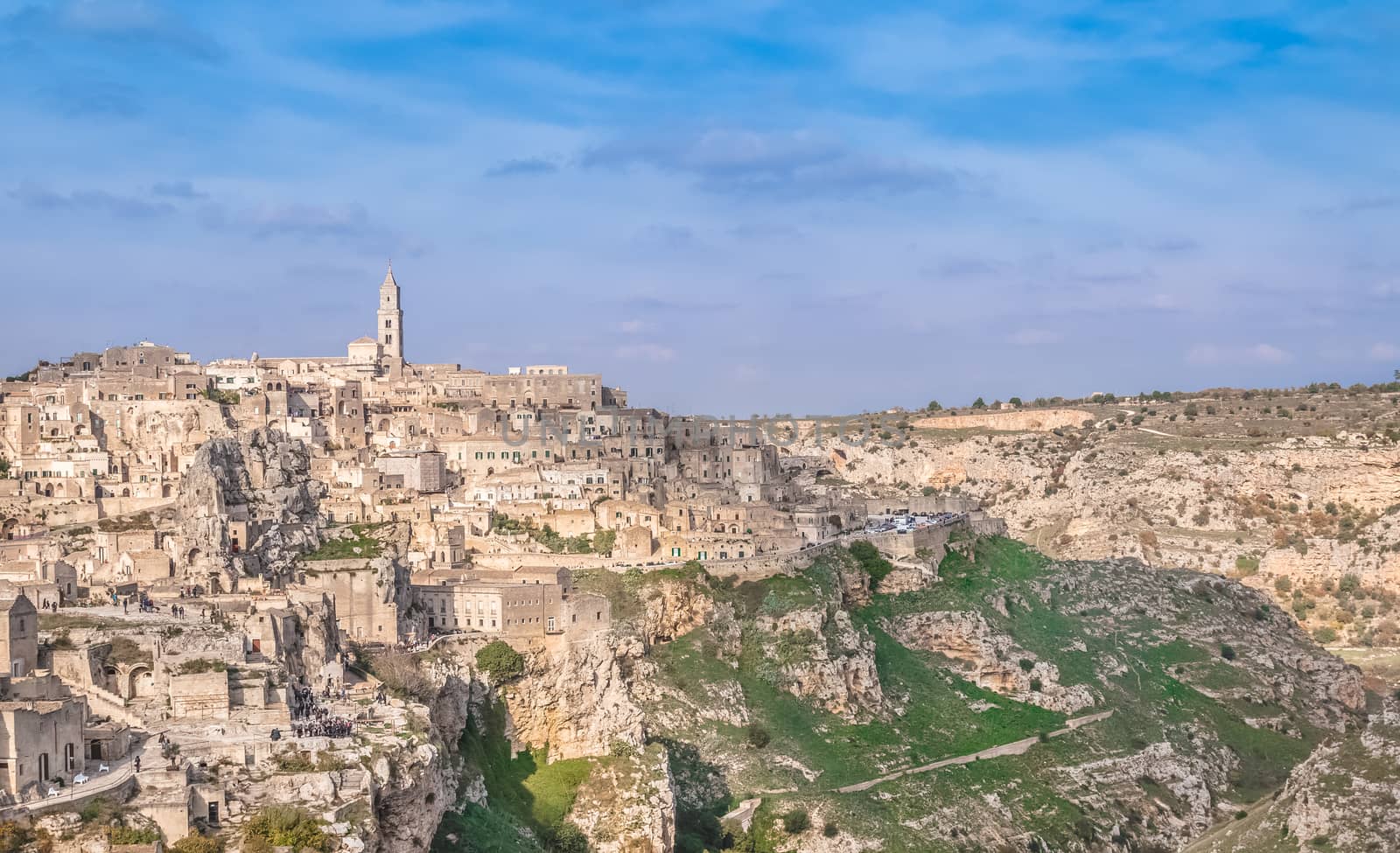 panoramic view of typical stones (Sassi di Matera) and church near gravina of Matera UNESCO European Capital of Culture 2019 on blue sky  by donfiore