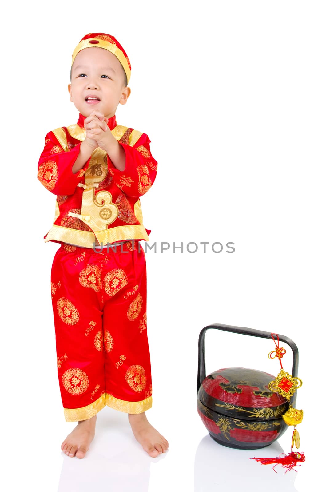 Chinese young boy in traditional Chinese cheongsam blessing, isolated on white background