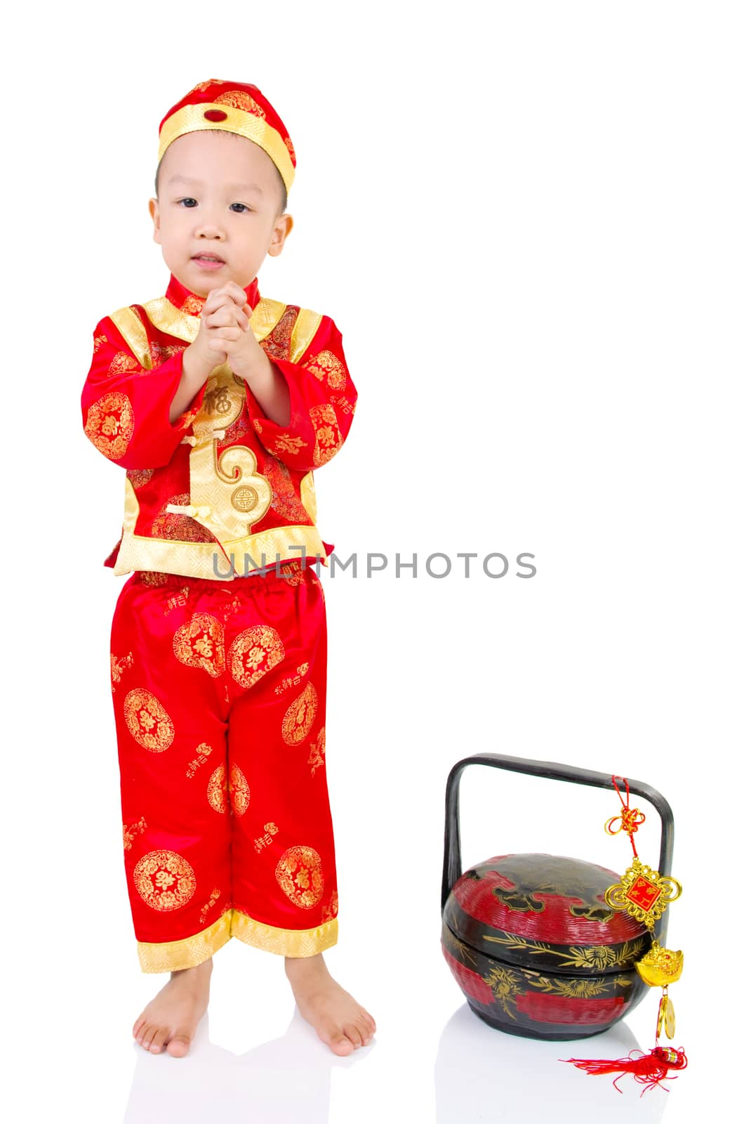 Chinese young boy in traditional Chinese cheongsam blessing, isolated on white background