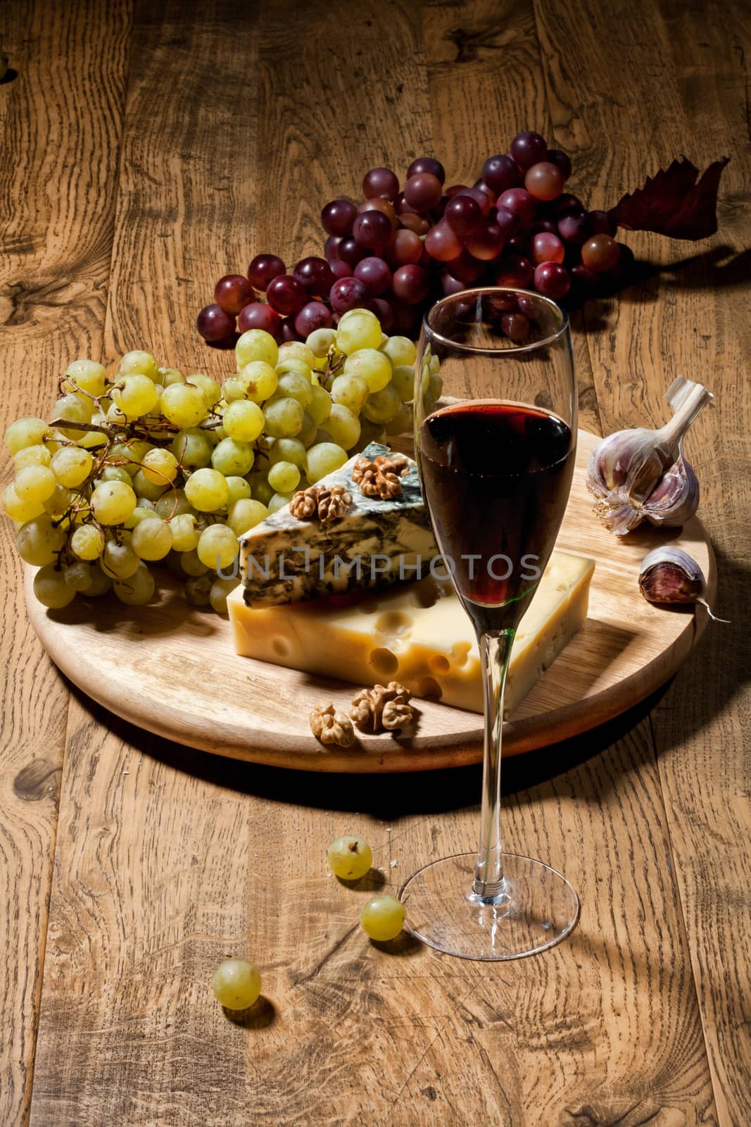 Winem cheese and grapes on a wooden table