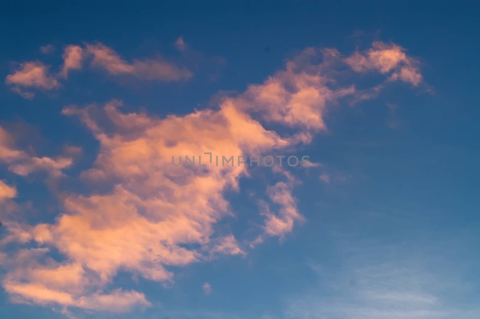 Autumn red gray clouds in the blue sky during the autumn sunset