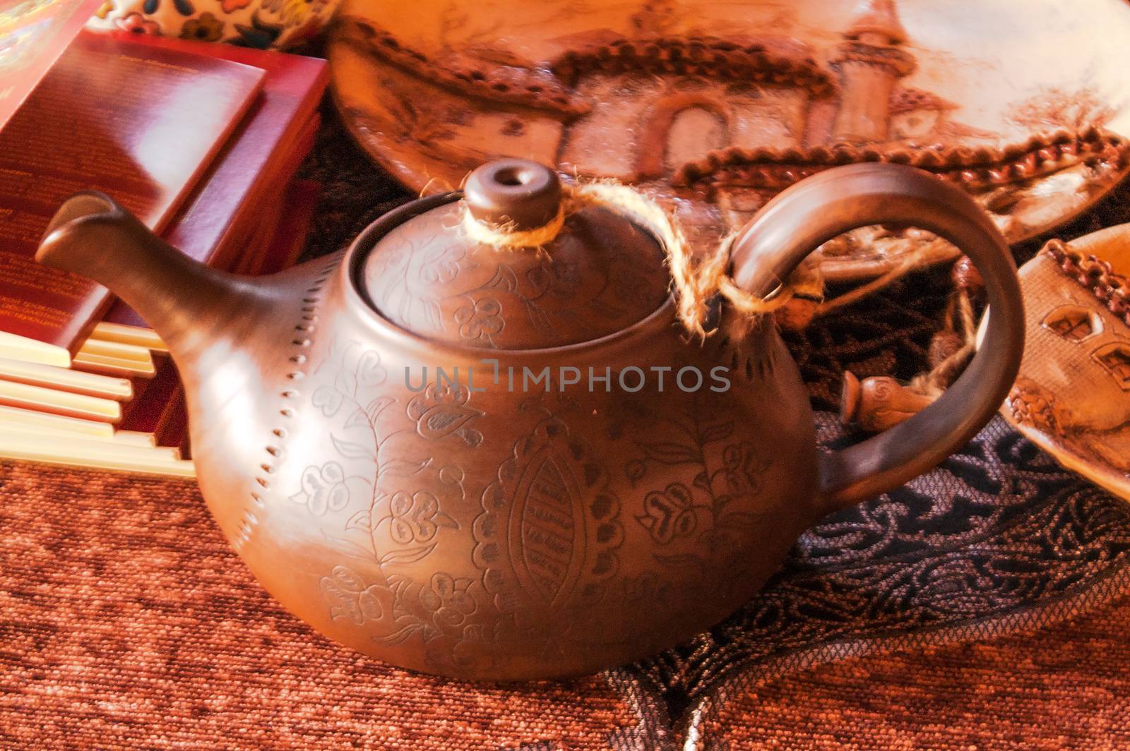 ancient clay teapot is handmade and a stack of books