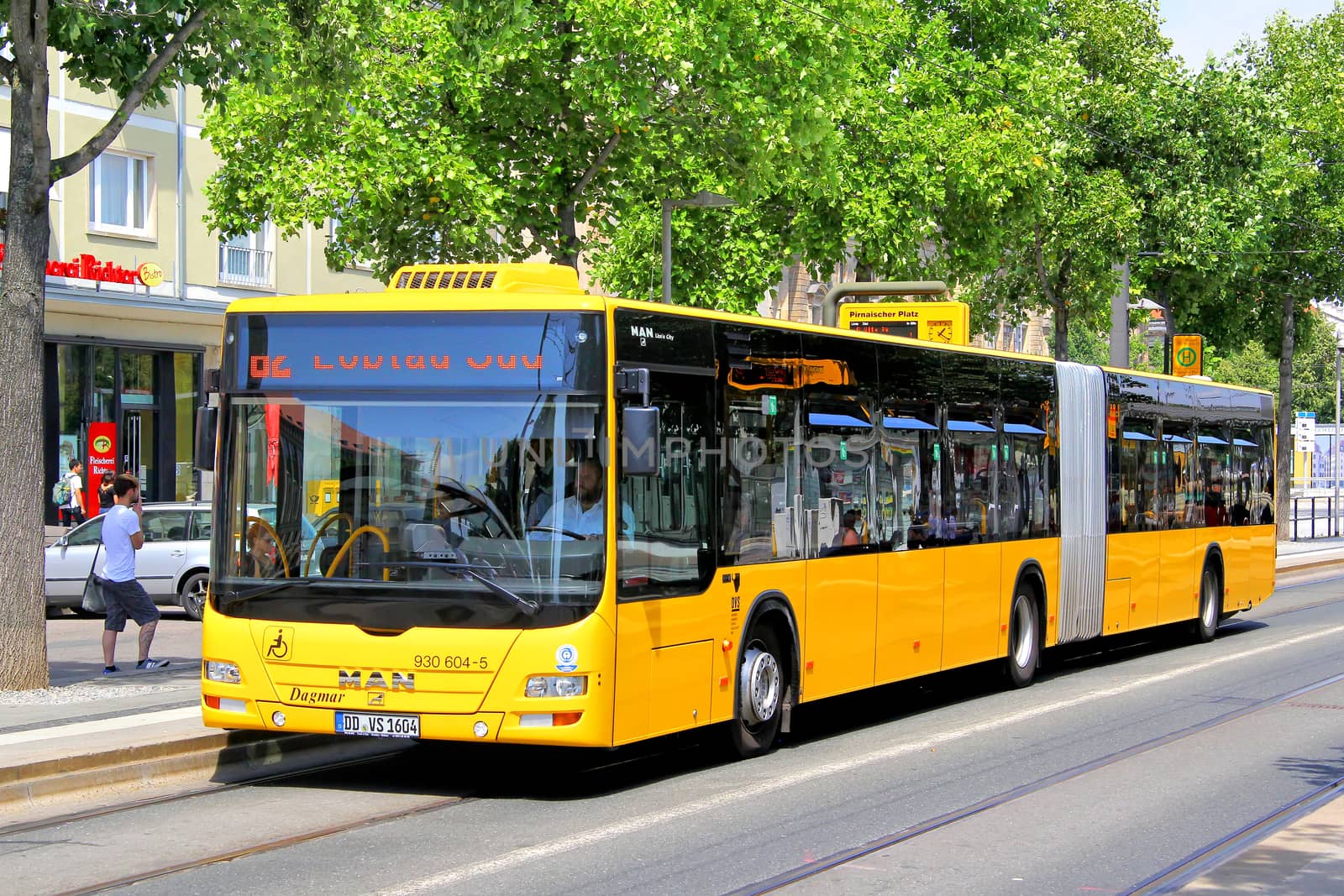 DRESDEN, GERMANY - JULY 20, 2014: Yellow articulated bus MAN A23 Lion's City GL at the city street.