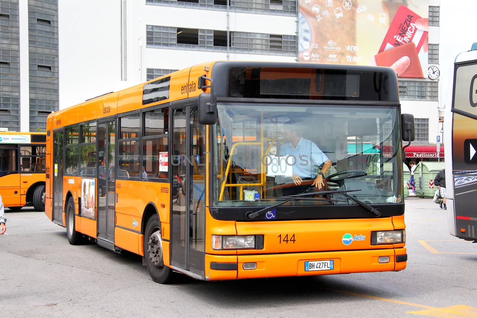 VENICE, ITALY - JULY 30, 2014: Orange city bus Iveco CityClass at the city street.