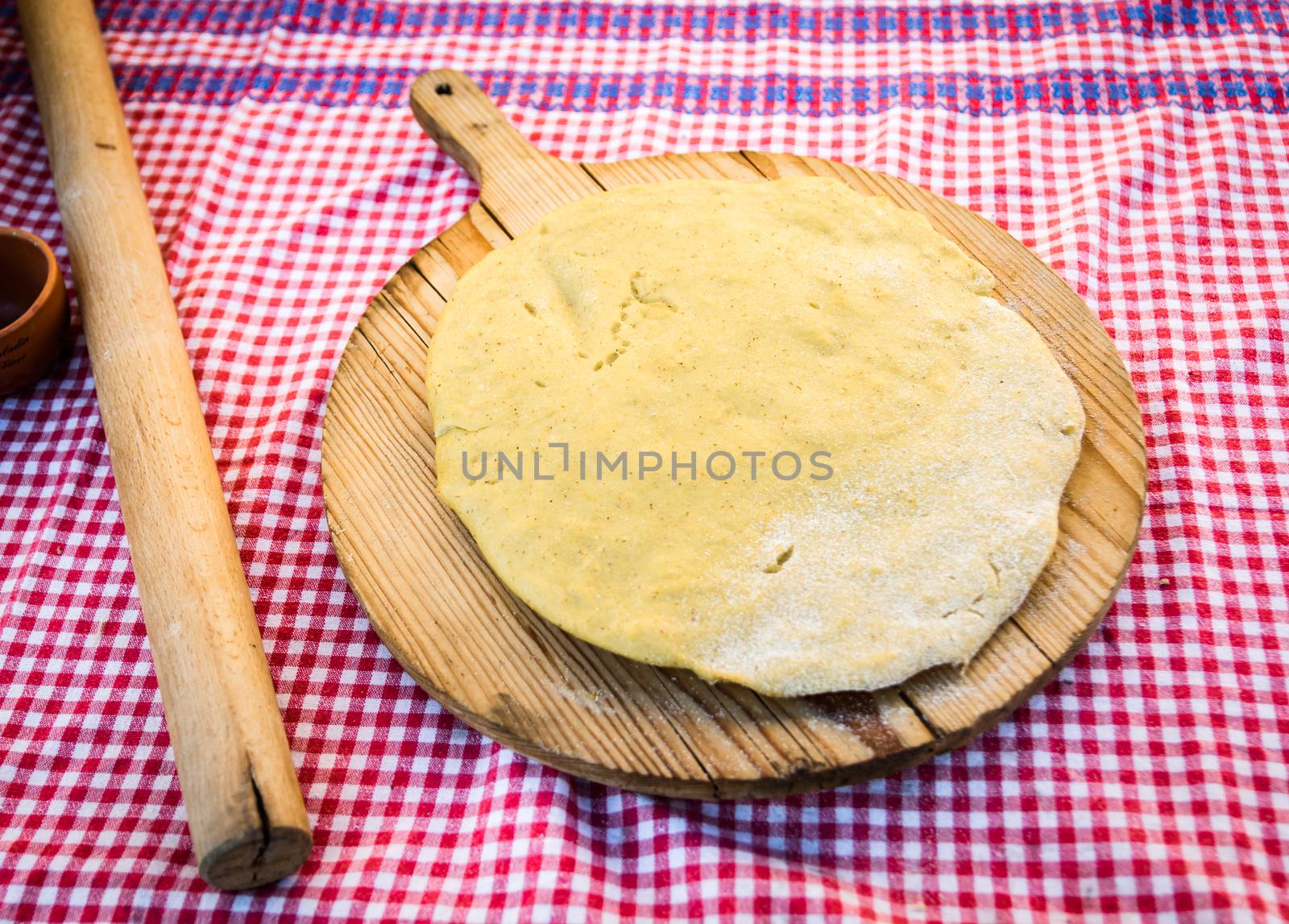 Polenta homemade on round wooden cutting board.
