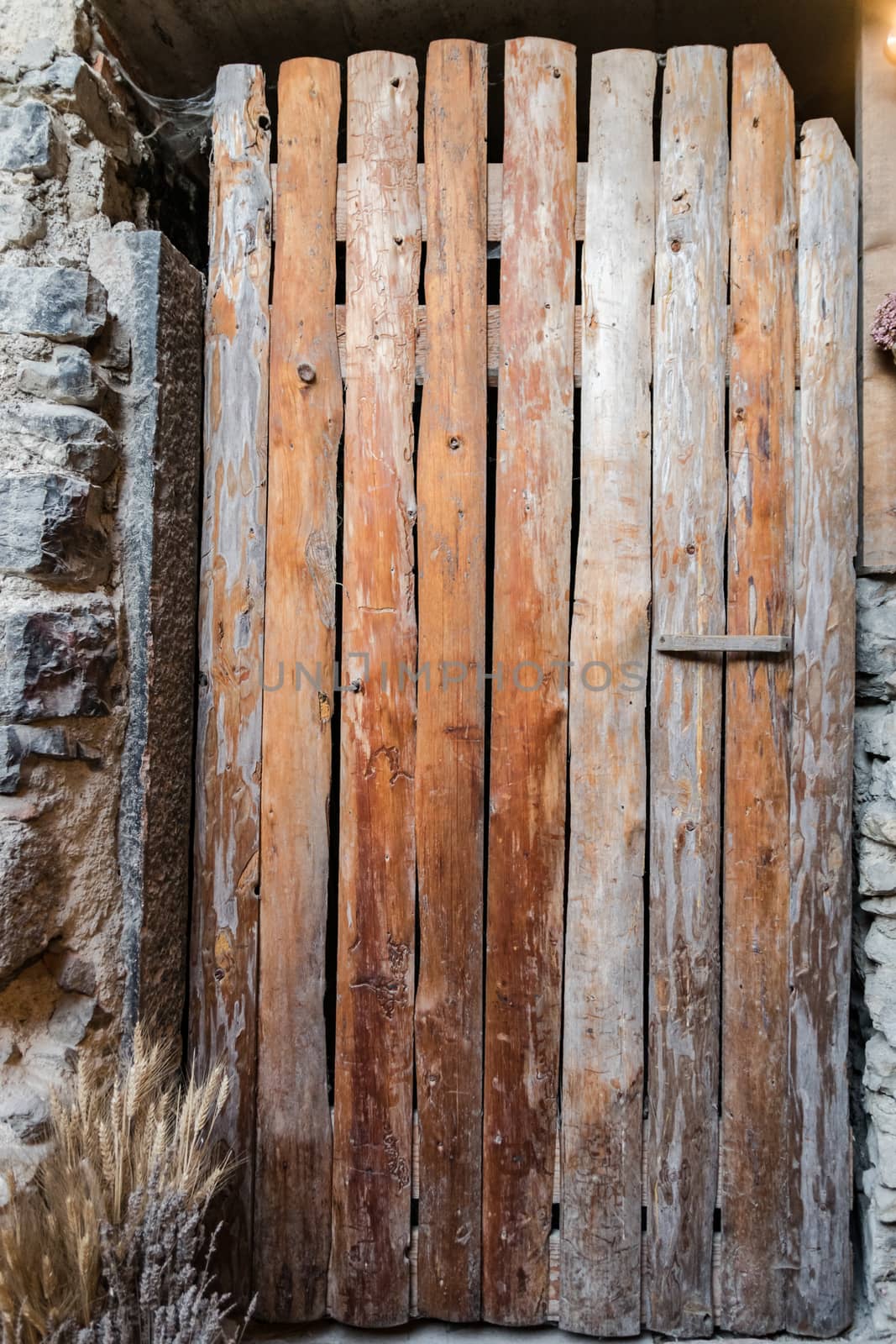 Old door made from rough planks of wood put together vertically.