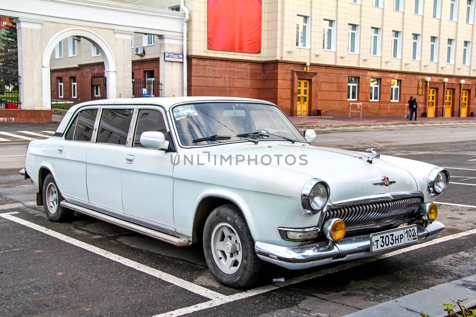 UFA, RUSSIA - OCTOBER 23, 2011: White retro styled limousine GAZ Volga at the city street.