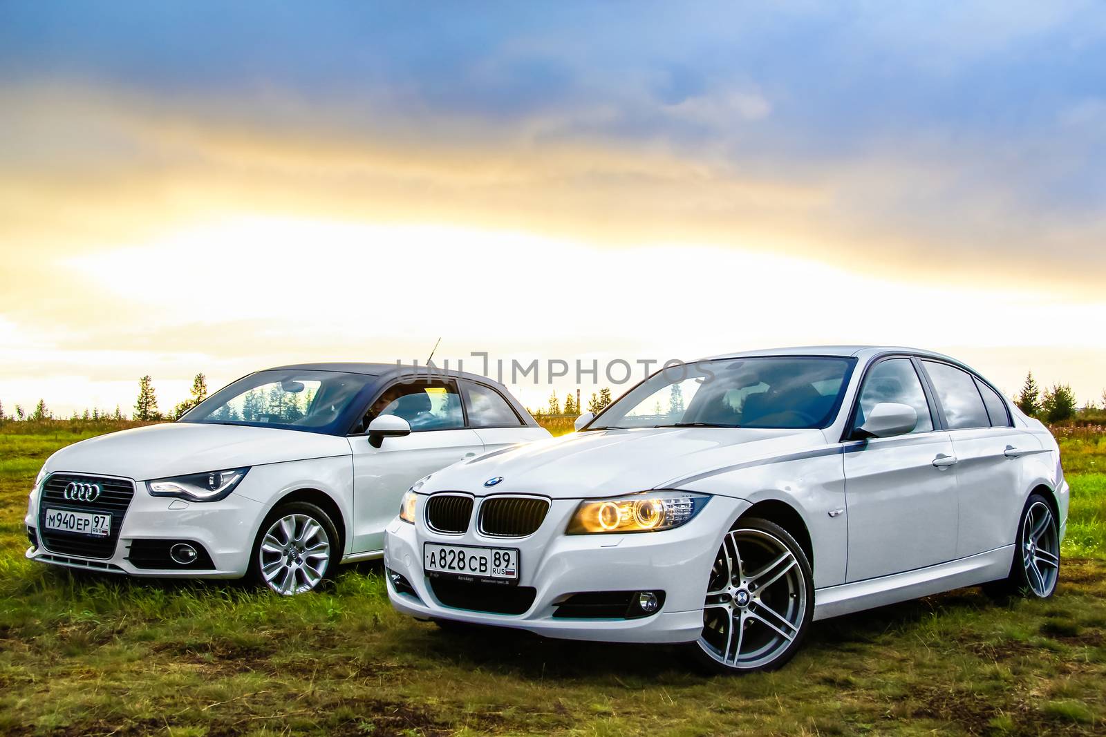 NOVYY URENGOY, RUSSIA - AUGUST 21, 2015: Motor cars Audi A1 and BMW E90 318i at the countryside.