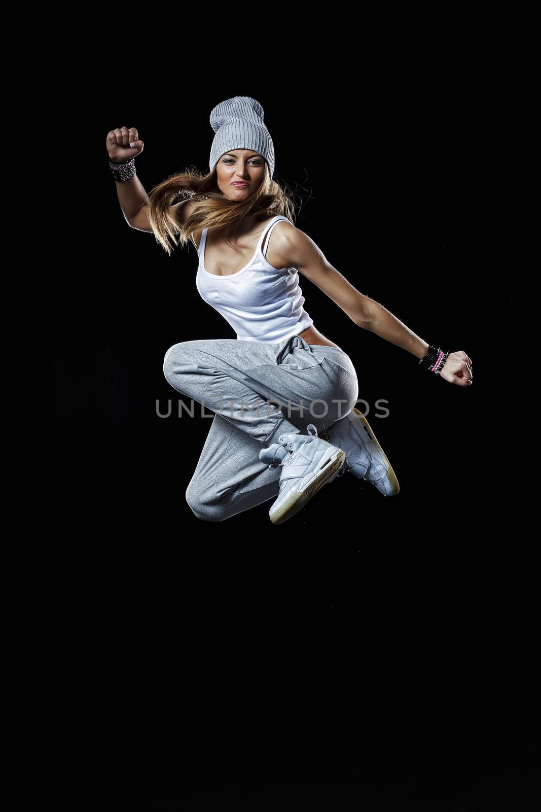 Beautiful model is jumping high on the black background. Studio shot