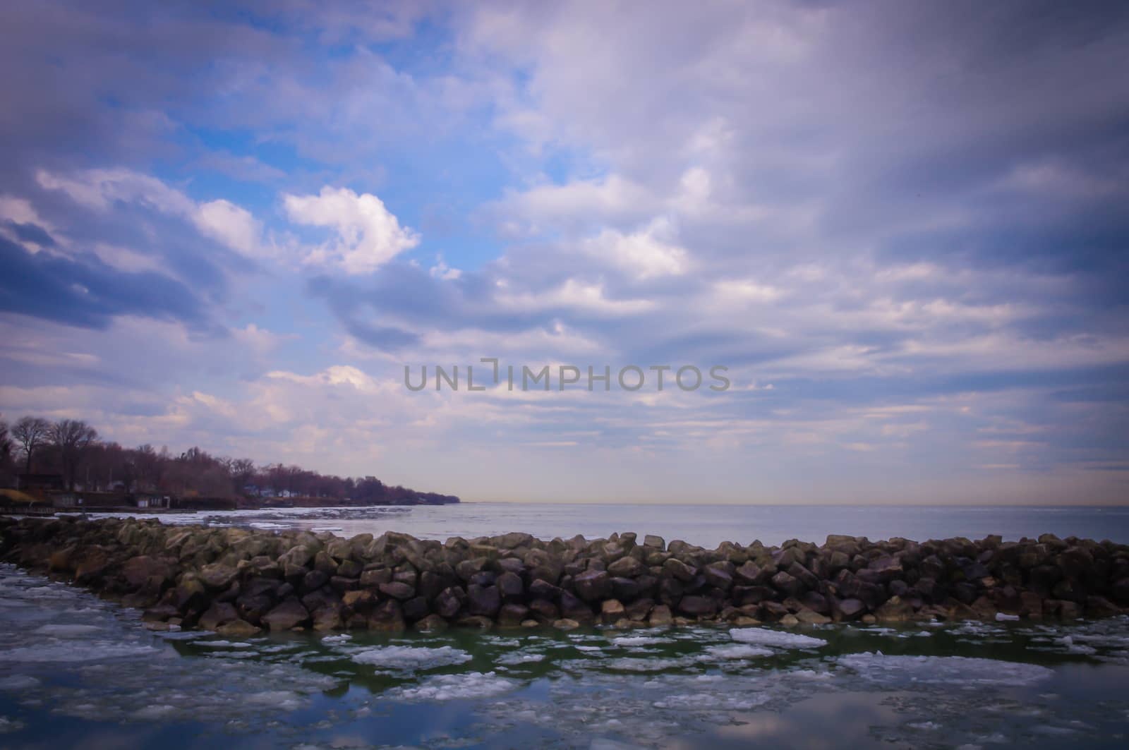 Winter scene with breakwall and ice floes at sunrise at Lake Erie