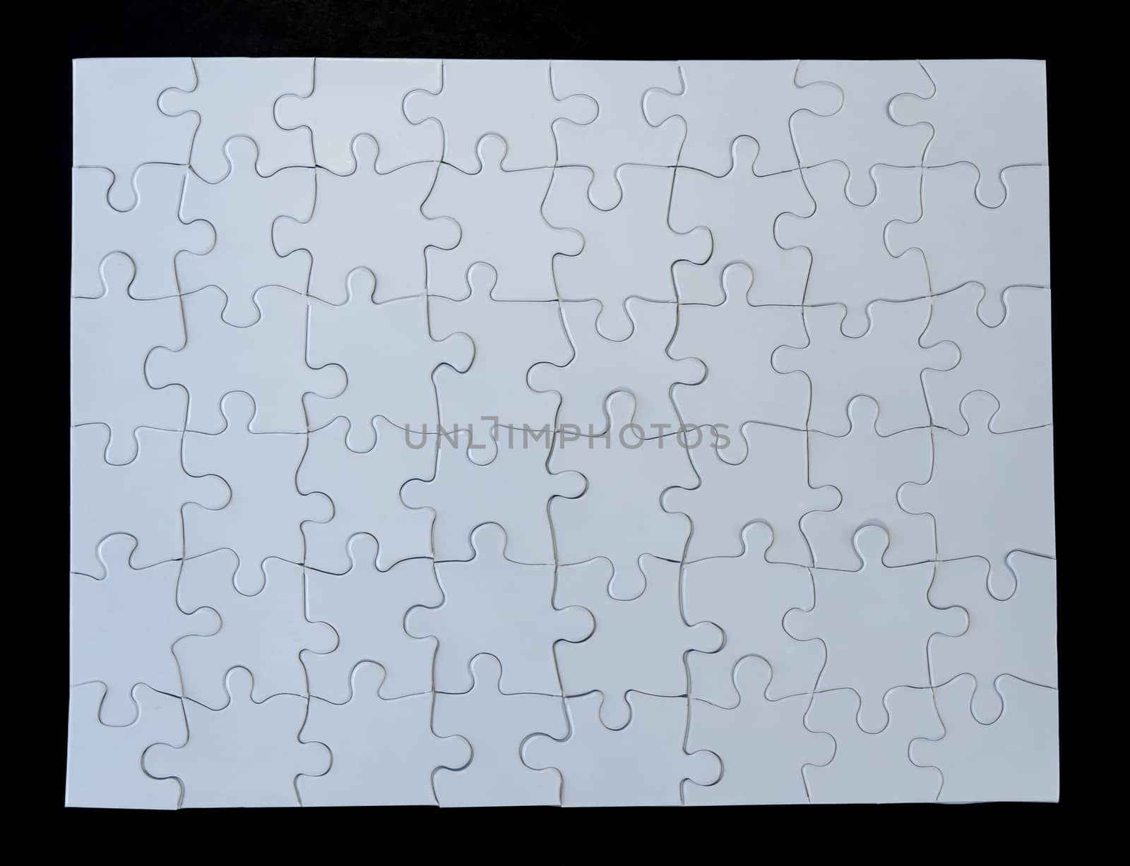 Completed white jigsaw puzzle on black background