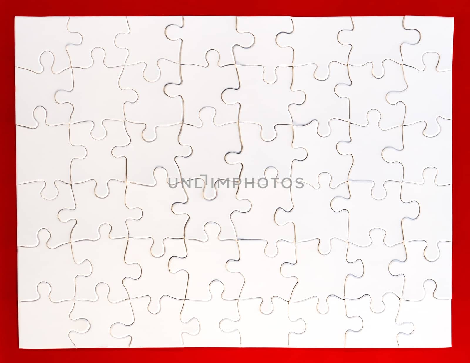 Completed white jigsaw puzzle on red background