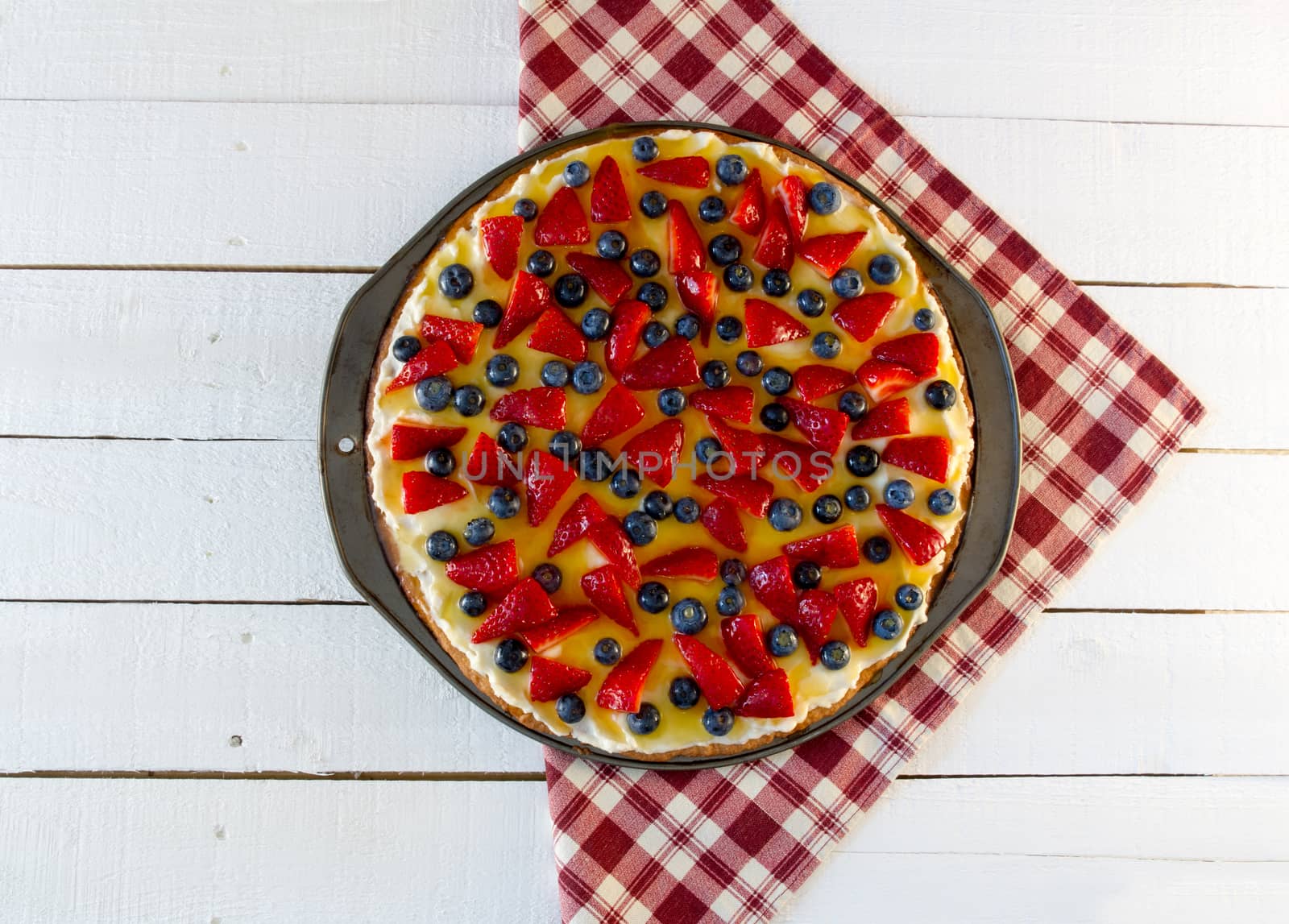 Fresh fruit pizza on red plaid cloth