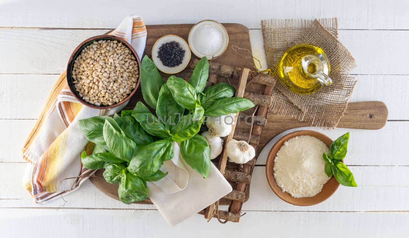 Fresh pesto ingredients on white rustic planks