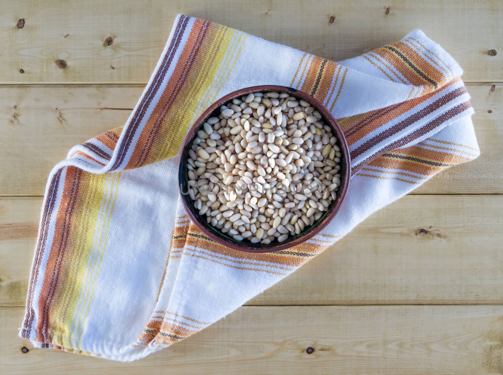 Pine Nuts in Pottery Bowl on Vintage Towel by krisblackphotography