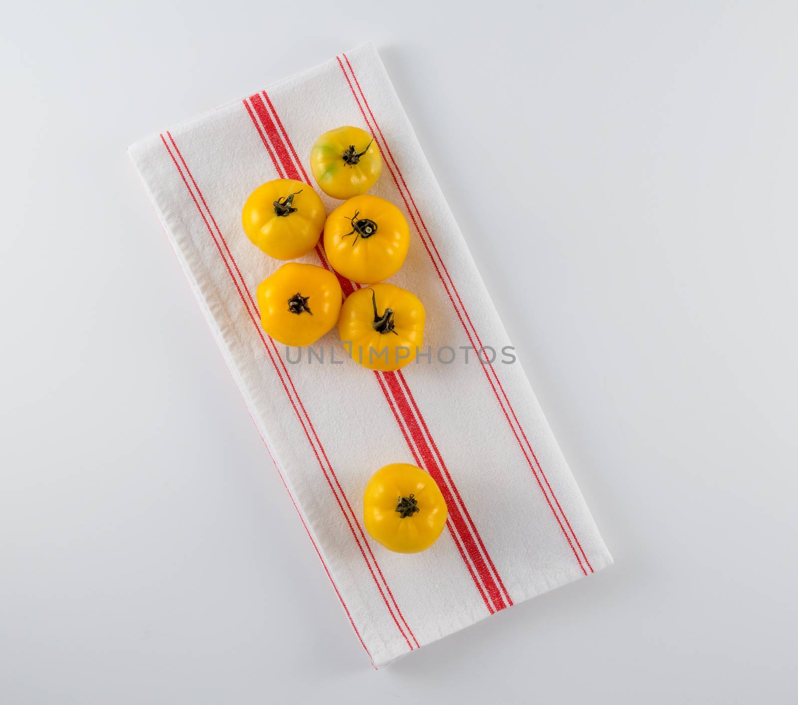 Vibrant yellow heirloom tomatoes on French tea towel