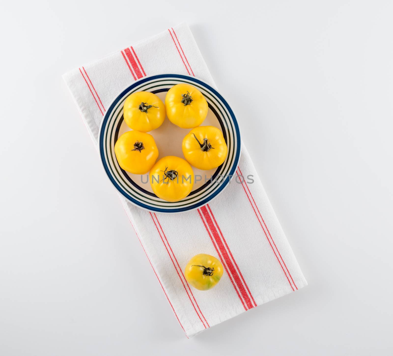 Yellow Heirloom Tomatoes on Stoneware Plate by krisblackphotography