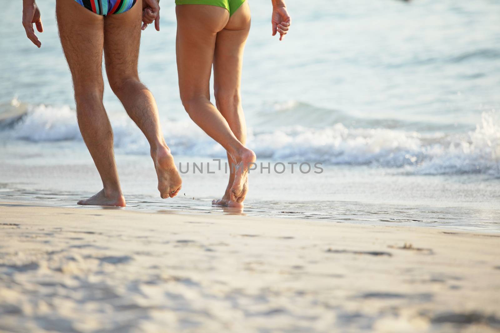 Close-up of people legs walking on beach