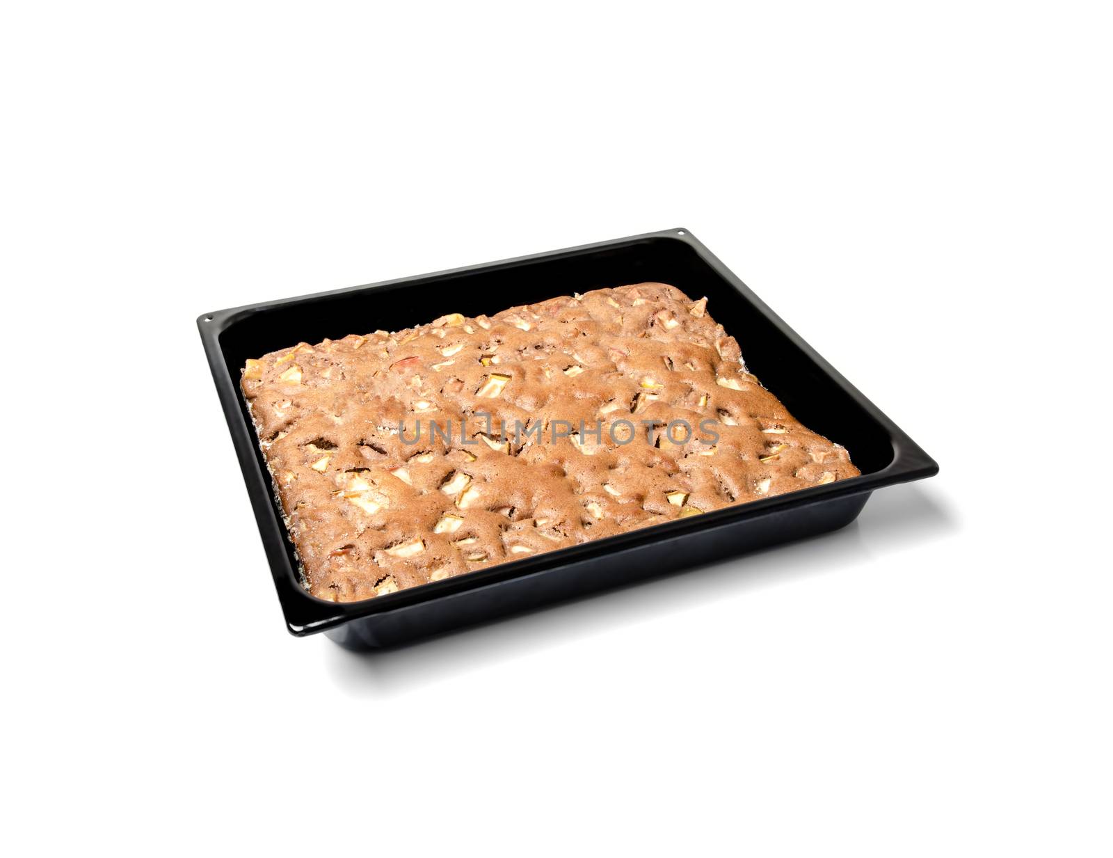 Apple pie on a black metal plate isolated on white background.