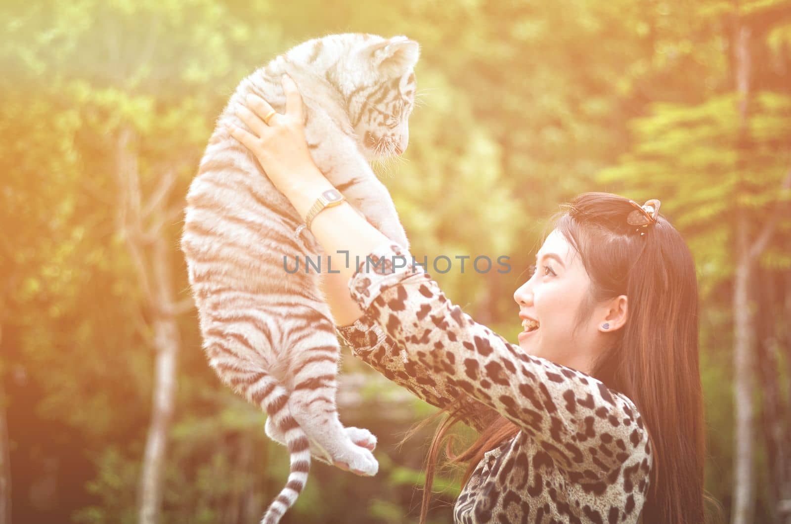 pretty women hold baby white bengal tiger with flare light