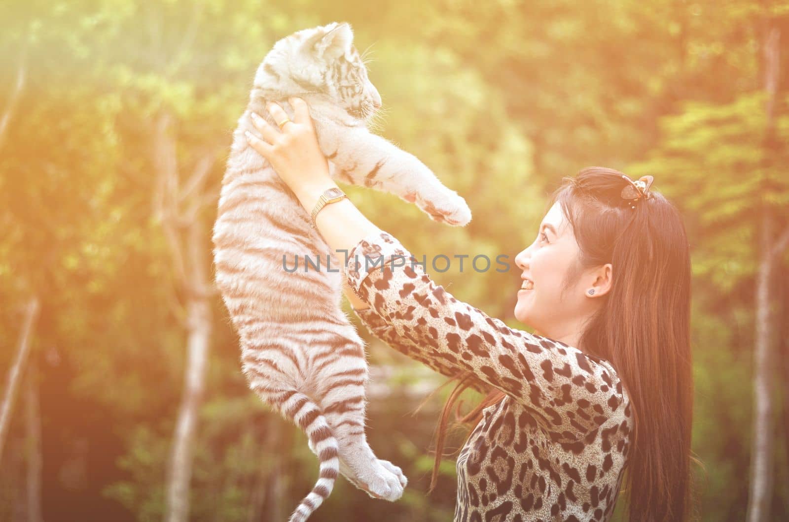 pretty women hold baby white bengal tiger with flare light