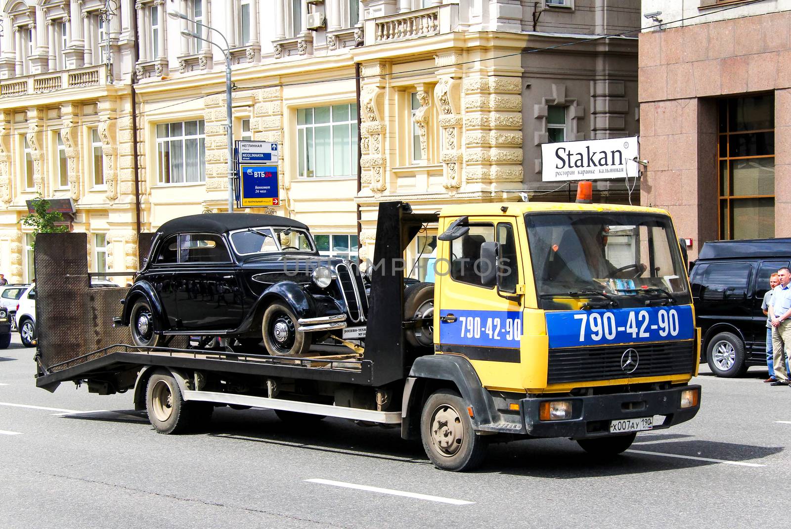 MOSCOW, RUSSIA - JUNE 2, 2013: Road rescue service truck Mercedes-Benz LK carrying a retro car BMW 321 at the city street.