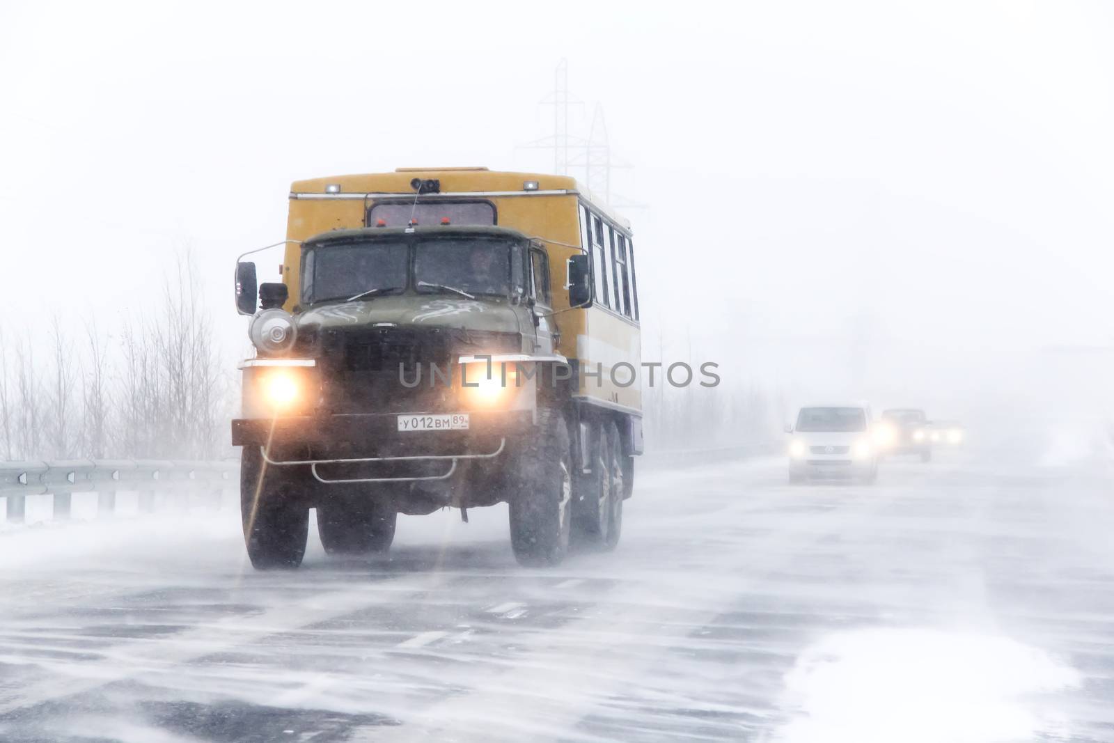 NOVYY URENGOY, RUSSIA - OCTOBER 20, 2013: Off-road bus Ural 4320 at the interurban freeway during a heavy blizzard.