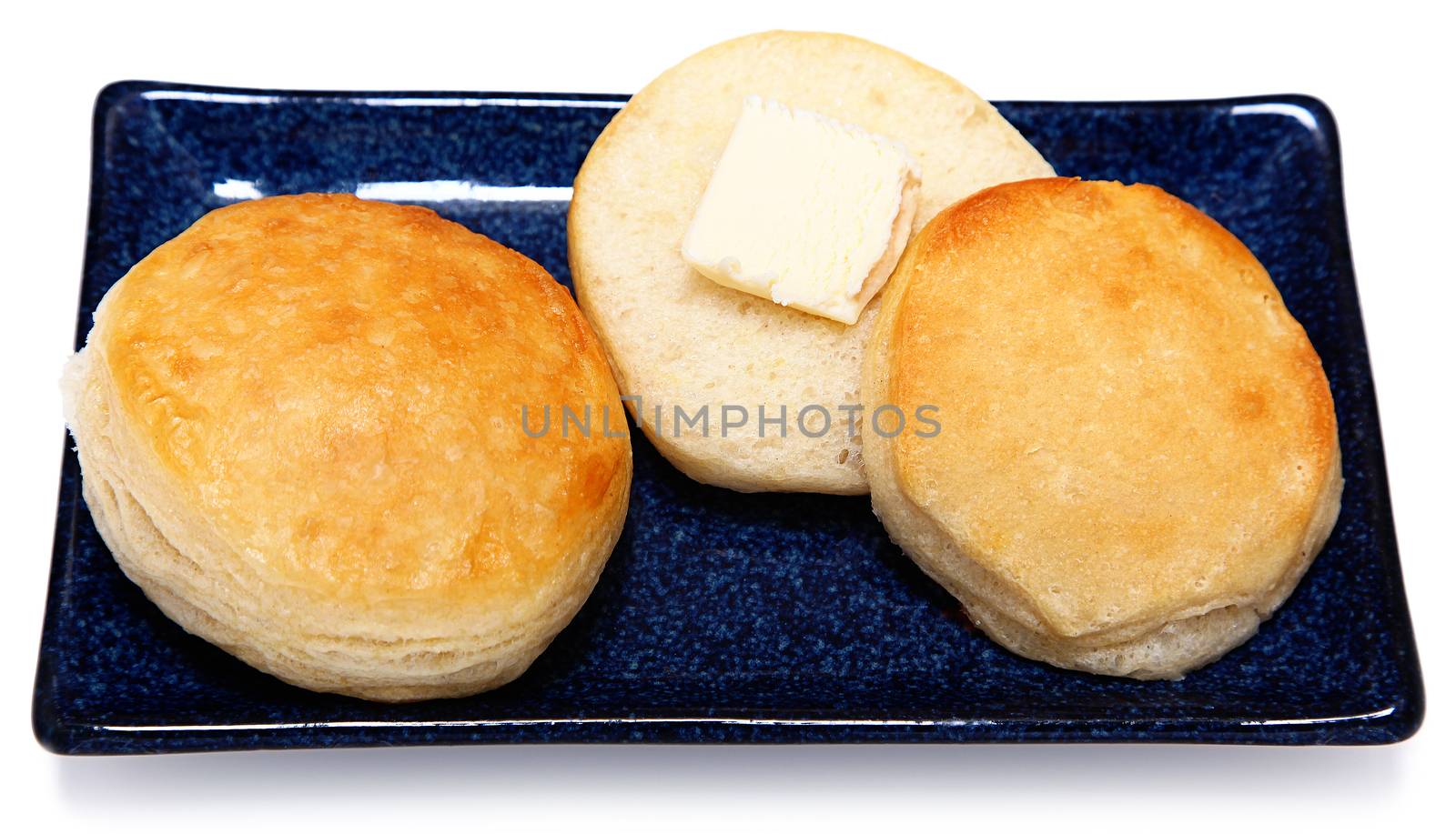 Golden Brown Fluffy Buttermilk Breakfast Buscuits with Butter on Blue Dish with White background.