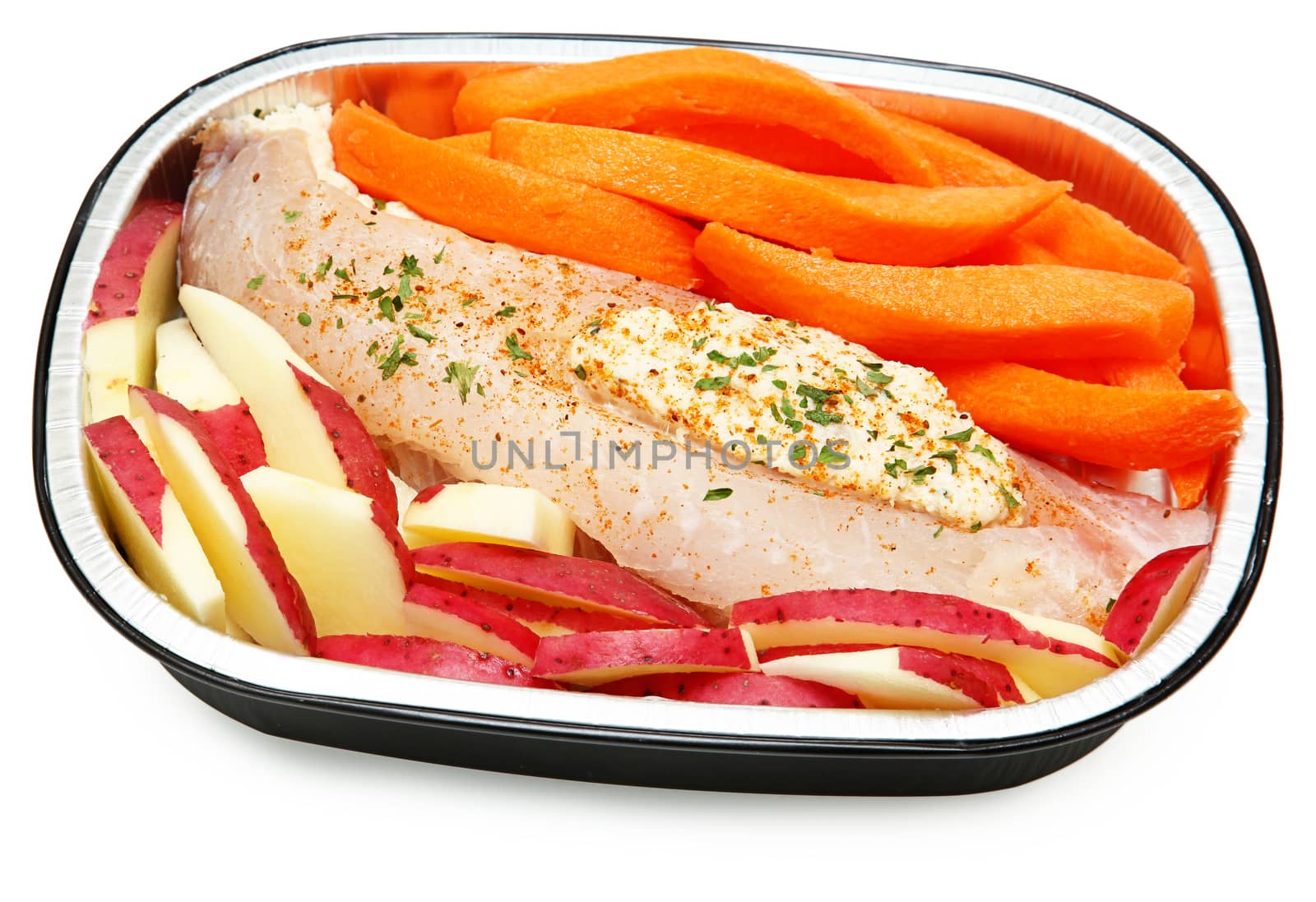 Raw Prepared Crab Stuffed Tilapia with carrots and potatoes Ready for the Oven. Isolated on white.