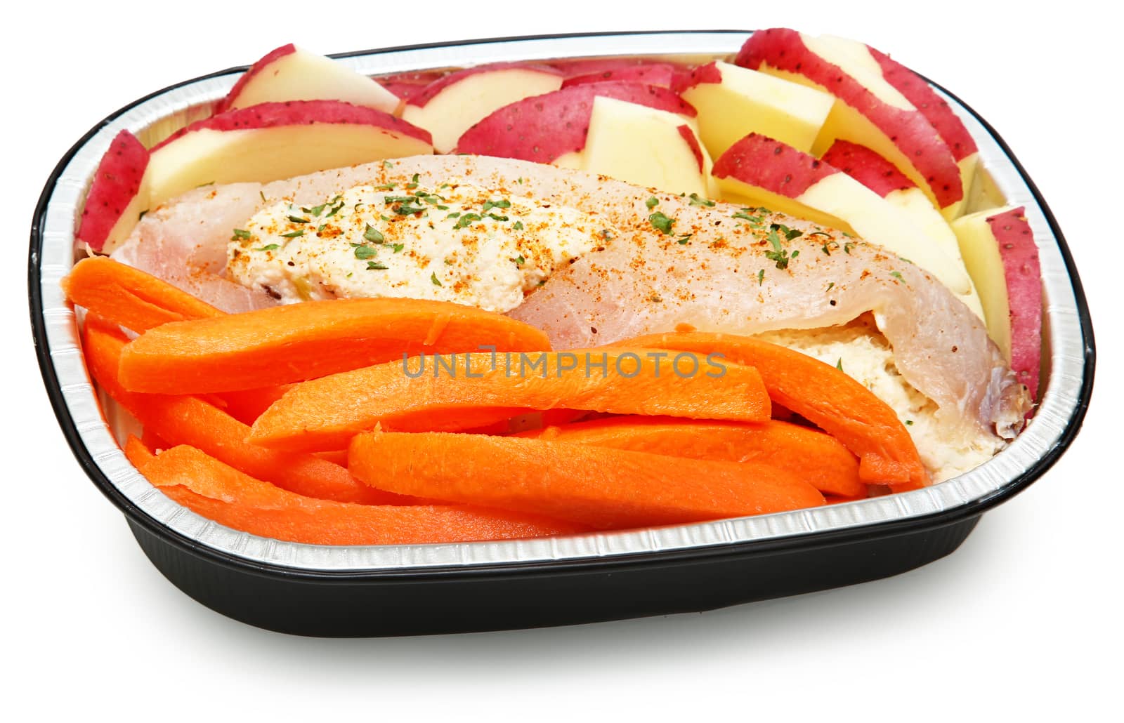 Raw Prepared Crab Stuffed Tilapia with carrots and potatoes Ready for the Oven. Isolated on white.