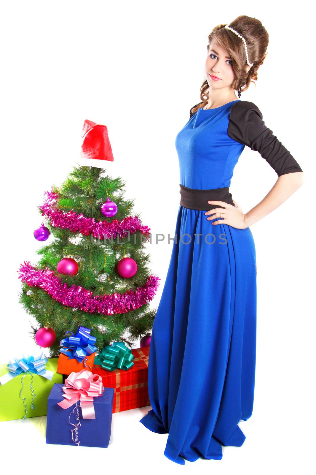 Portrait of a beautiful young woman near the Christmas tree and presents isolated over white background