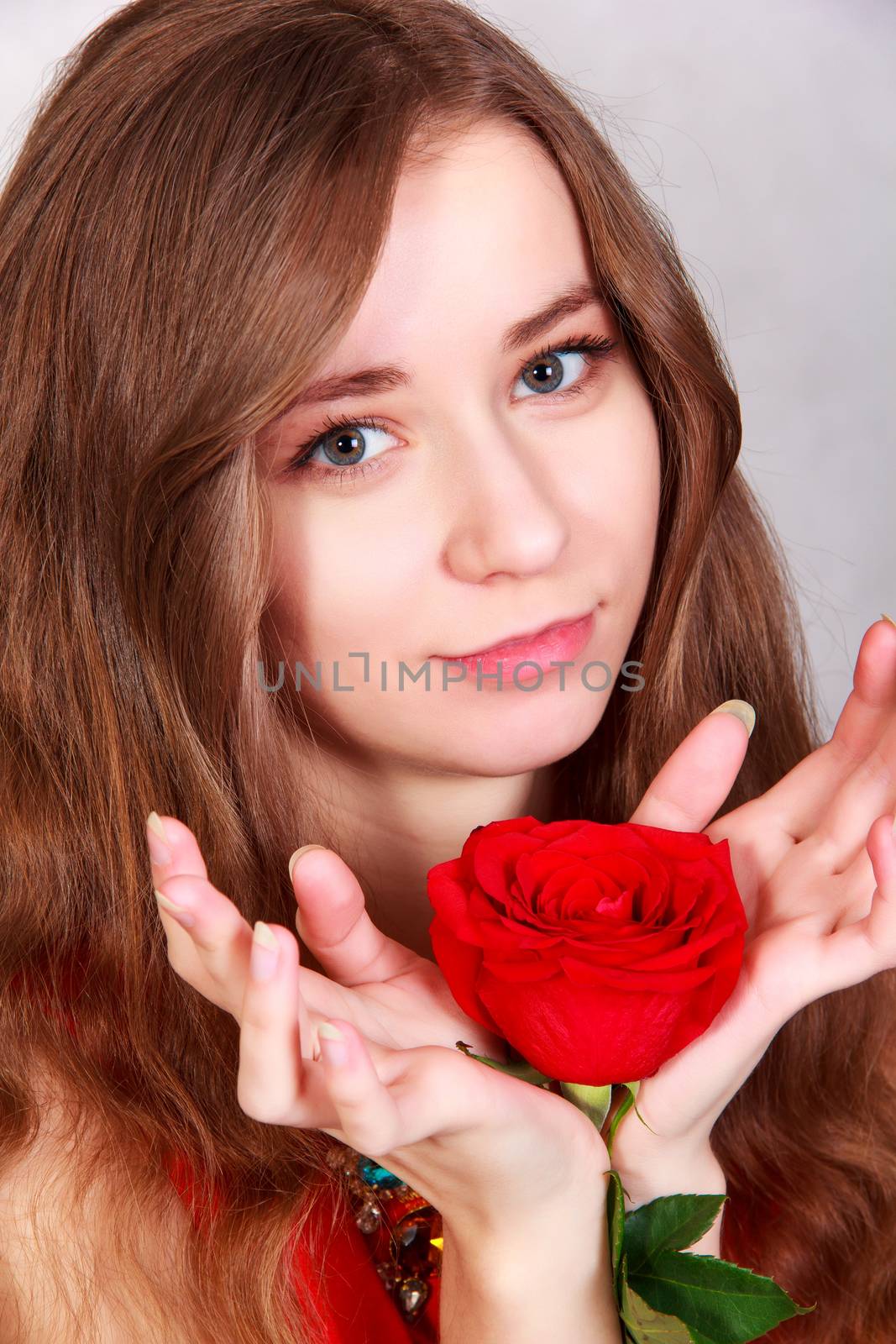 Closeup portrait of a young attractive woman with a red rose by Artzzz