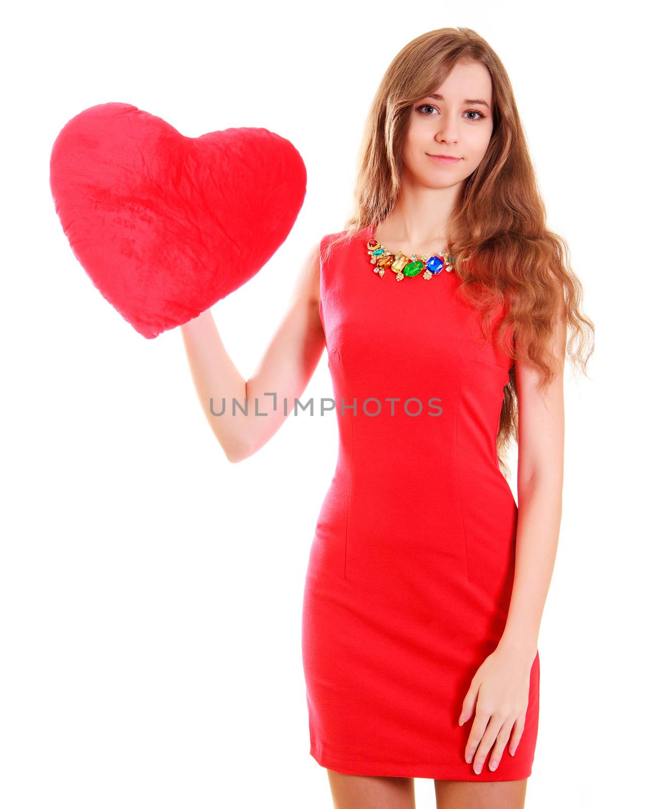Portrait of a young attractive woman with a heart-shaped pillow isolated over white background