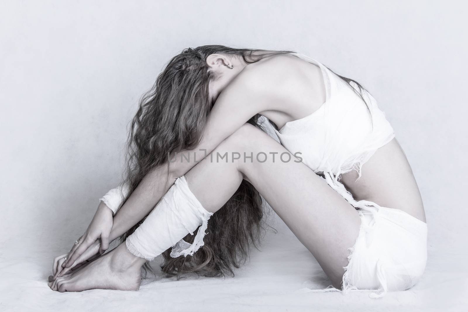 Pretty young woman with a bandage dressings on her body over grey background