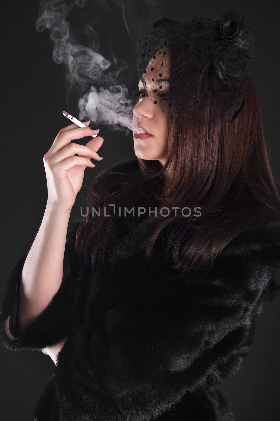 Portrait of a young attractive woman smoking a cigarette by Artzzz