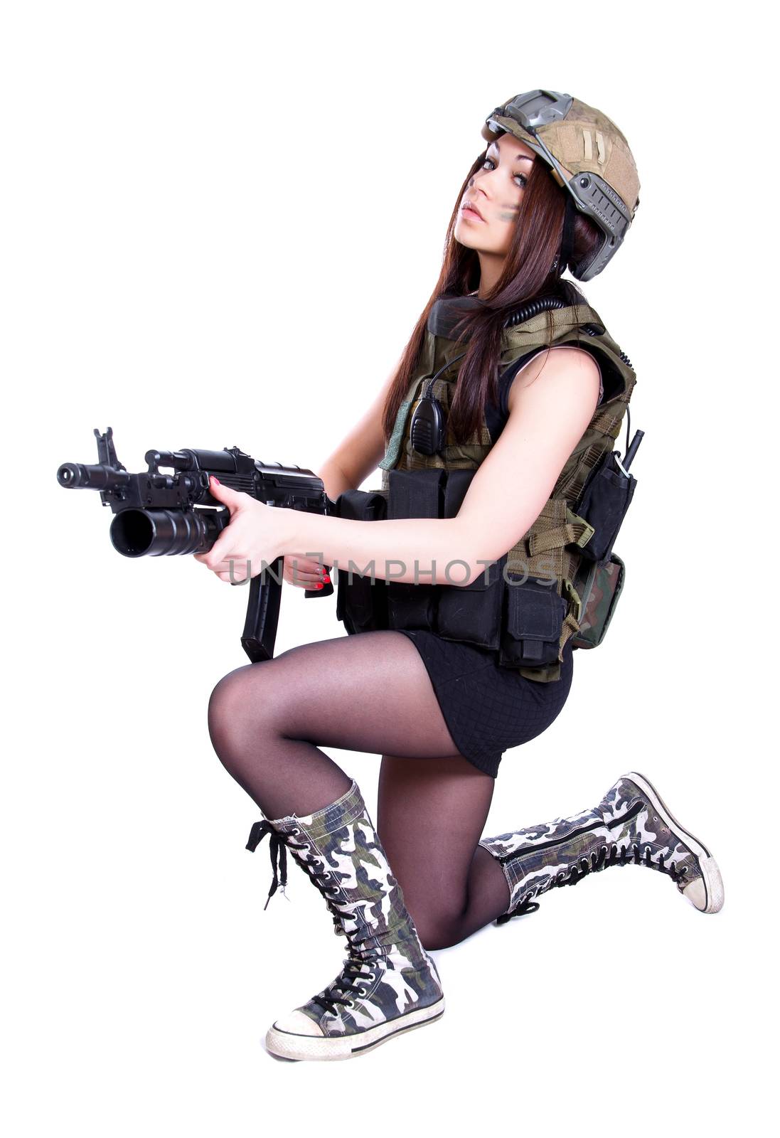 Woman in a military camouflage sitting with the assault rifle isolated over white background
