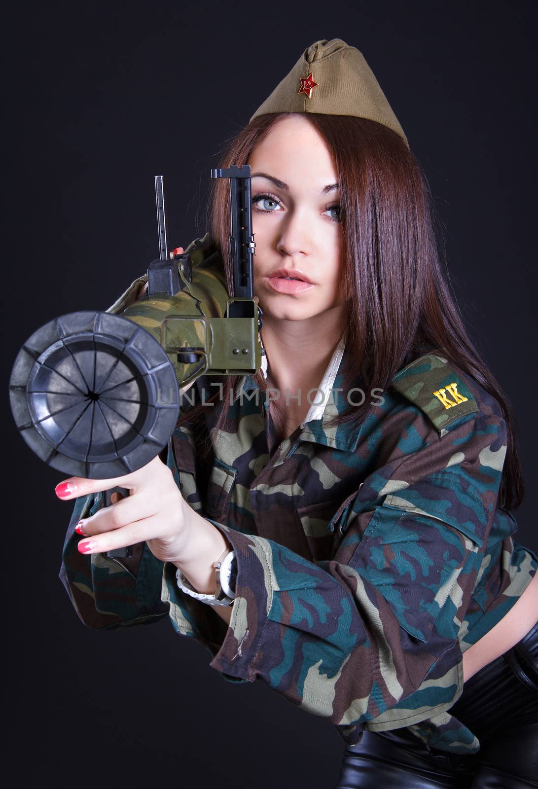 Woman in the military uniform with a grenade launcher over black background